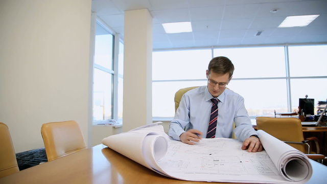 businessman architect of the drawings in his office