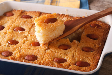 Basbousa pie with almonds macro in a baking dish. Horizontal
