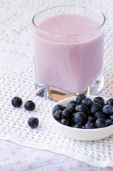 Blueberry yogurt in a glass with a spoon and blueberries