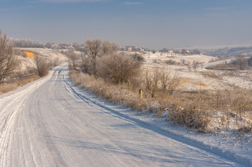 Obraz na płótnie Canvas Winter landscape with country road leading to Novo-Nikolaevka village in Dnepropetrovskaya oblast, Ukraine