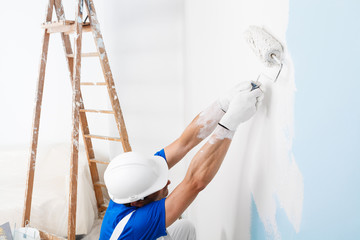 painter painting a wall with paint roller