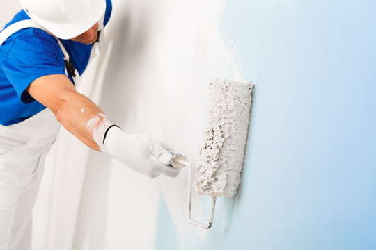 painter painting a wall with paint roller