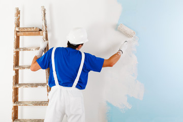 painter painting a wall with paint roller - 101692341