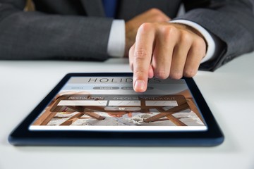 Composite image of businessman using digital tablet