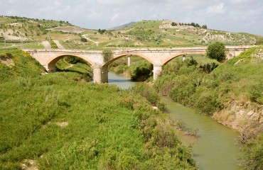 Fototapeta na wymiar Hilly agricultural landscape with old bridge near town Ribera, Sicily, 