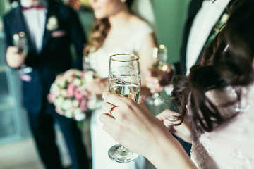 bridesmaid holding glass with champagne on wedding