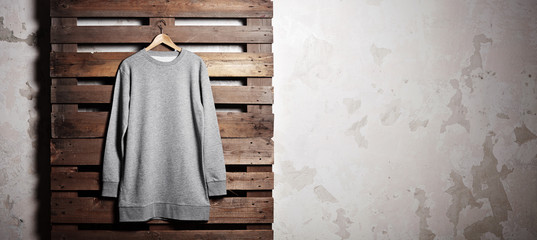 Photo grey hoody  hanging in front of wood background