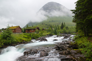 Fototapeta na wymiar Landscape with wooden houses, river and mountain, Norway