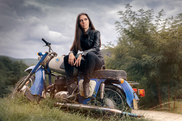 Obraz na płótnie Canvas Biker Girl in Leather Jacket on Retro Motorcycle