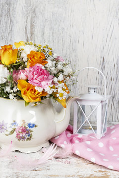 Romantic bouquet of flowers in vintage kettle