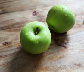 Couple of fresh apples on a wooden board.

