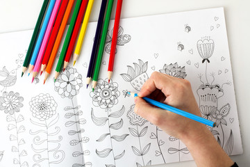 colorer - antistress with colored pencils.The woman draws thereby relieves stress