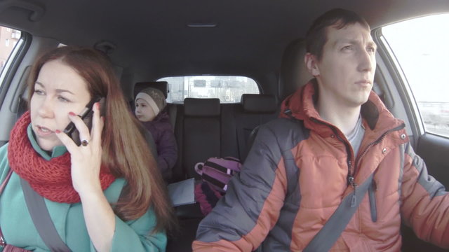 Father, Mother And Daughter Travel In Car Together, Woman Speaking The Cell Phone, Camera Moving Left