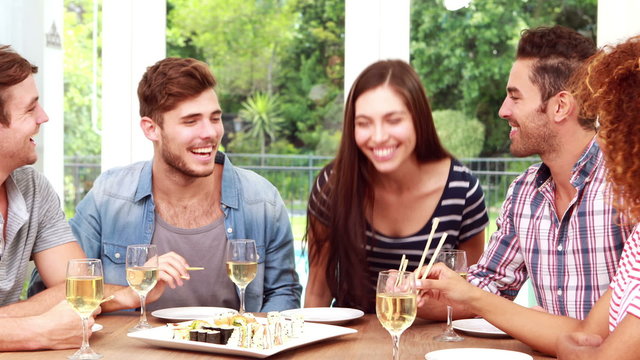 Happy friends eating sushi