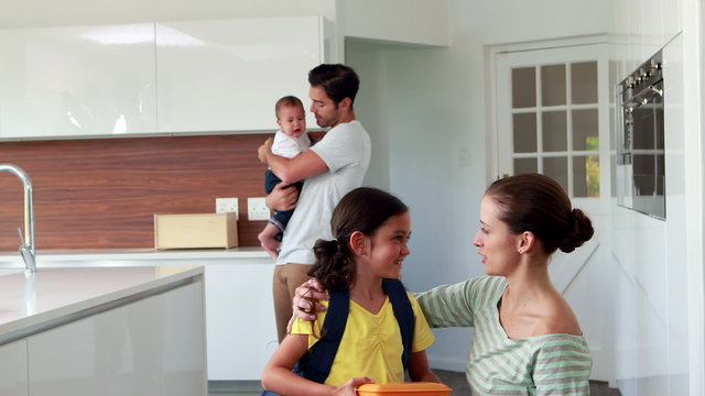 Child ready to school in the kitchen with family