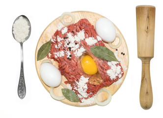 mincemeat with eggs, rolling-pin and spoon on a board