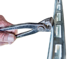 Old and dirty pliers cutting aluminium on white background