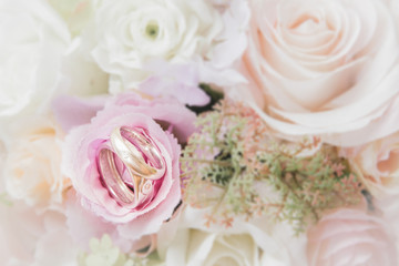 Obraz na płótnie Canvas wedding rings on flower bouquet