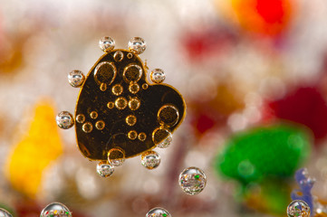 Colorful hearts underwater with bubbles of air - close-up macro