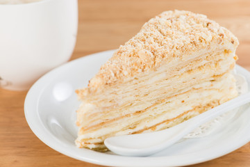 Delicious cake on plate on table on a wooden background