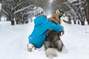 happy boy hugging dog or husky outdoors in winter day © dreamsnavigator