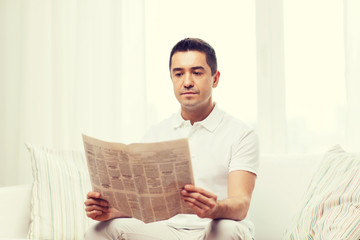 man reading newspaper at home