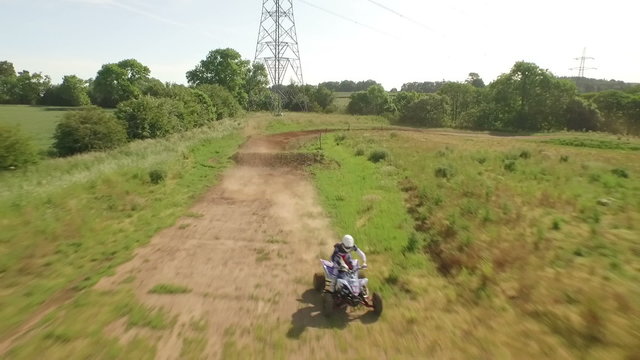 Tracking drone shot of quad bikes / off road vehicle on a dusty dirt track  
