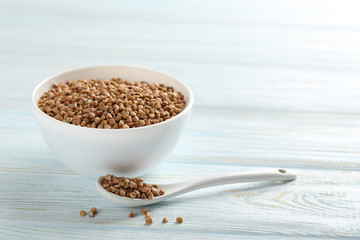 Buckwheat seeds in bowl on a blue wooden table