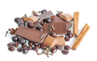 Cracked chocolate bar and  spices isolated on white. Selective focus