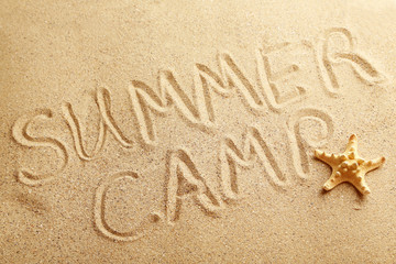 Summer camp handwritten in a beach sand