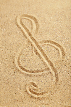 Violin key drawn on a beach sand