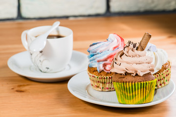 cakes on a saucer with a coffee on a wooden background (shallow