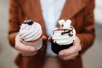hand holding cupcake decorated with blackberry
