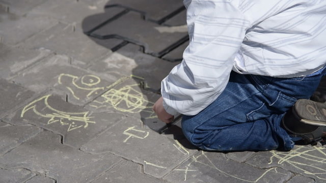 Little child drawing with chalk outdoor