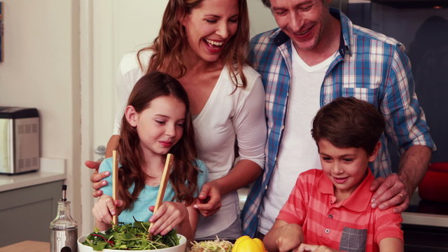 Happy family preparing salad together