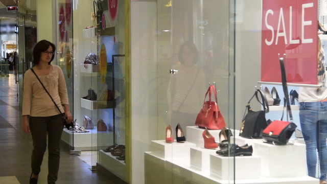 Young woman looking at shoes and bags in the shop