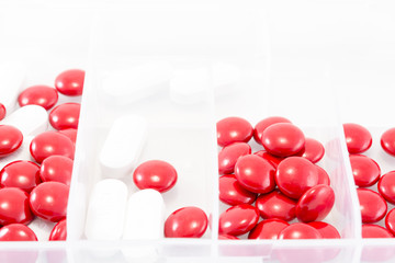 Red and white pills in box on a white background