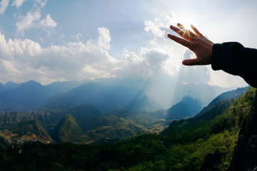 Touch to the sun. Hand touching the sky with ray. Freedom concep
