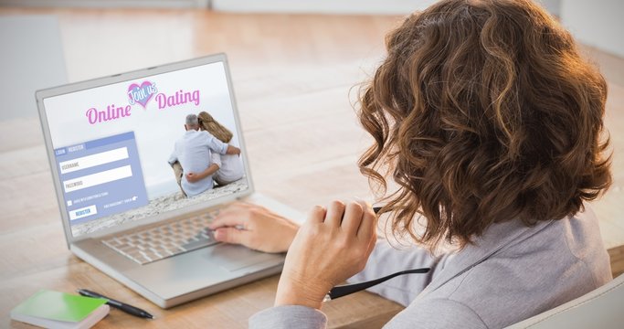 Composite image of businesswoman using laptop at desk 