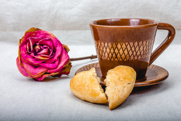 Broken heart cookies, cup of coffee, dried rose