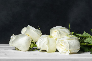 White roses on white boards.  - Powered by Adobe