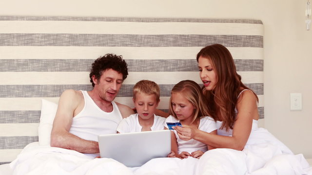 Happy family shopping online with laptop