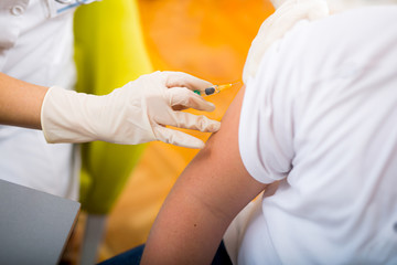Teenage boy getting vaccination in his arm, close up