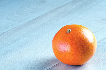 One whole grapefruit on the table on the right
