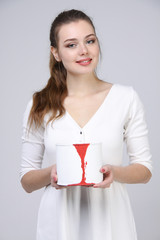 girl in white dress holding paint can