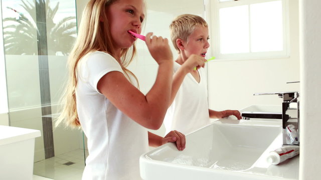 Siblings washing teeth together