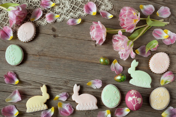 Easter cakes in the form of eggs and tulips on wooden background