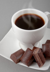 black coffee and chocolate on a grey background