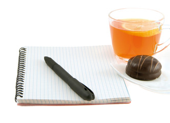 Fototapeta na wymiar notebook with a pen and tea with a lemon on a white background