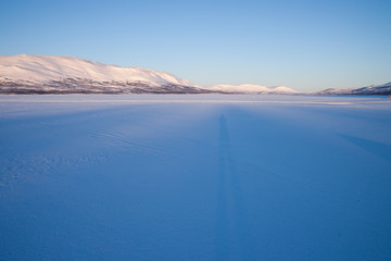 Morgenstimmung über einem zugefrorenen See in Schweden